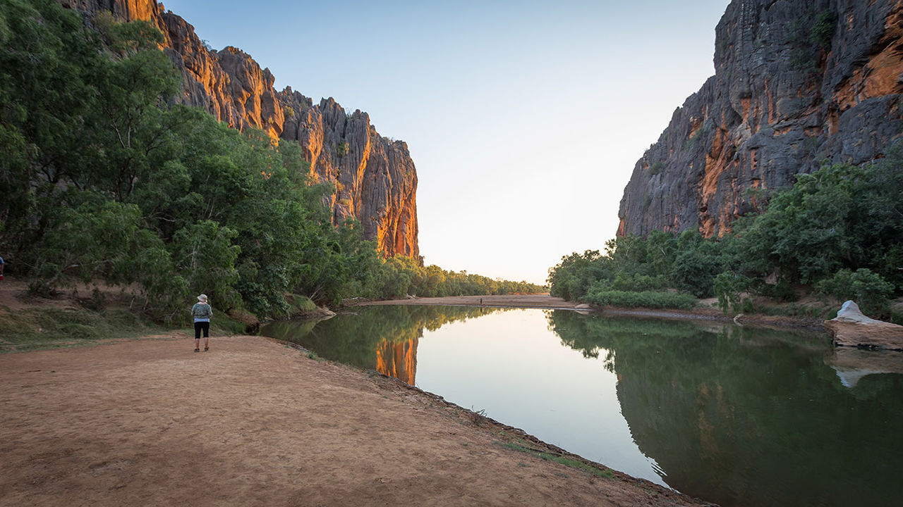 The Lennard River carves a stunning canyon through the Napier Range at Windjana Gorge, Kimberley Region, Western Australia. The permanent pools in the river provide a permanent habitat for dozens of freshwater crocodiles. Rudyards Kipling's story "The Elephant Child," comes to mind every time I visit Windjana Gorge in the Kimberley,  when the Elephant child says: "and still I want to know what the Crocodile has for dinner!'Then Kolokolo Bird said, with a mournful cry, 'Go to the banks of the great grey-green, greasy Limpopo River, all set about with fever-trees, and find out."At Windana Gorge the green waters of the gorge pools are filled with  Johnston crocodiles floating in the tepid green waters or resting on the hot sand banks.They add a real air of wild Australia below the complex and colourful ramparts of the Gorge where the Leonard River flows through the ancient Devonian reefs.The history of the renegade aboriginal tracker Jandamarra who hid in caves in this gorge and the screeching of the galahs circling overhead and wheeling about amongst the crags further adds to the primeval atmosphere of this special place in Australia.